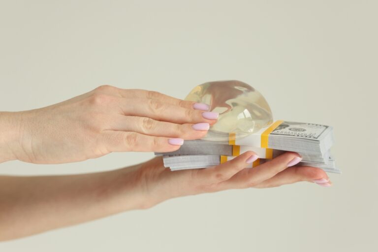 Woman holding silicone breast implants and money
